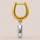Gold and silver earring with a diamond on a beige background