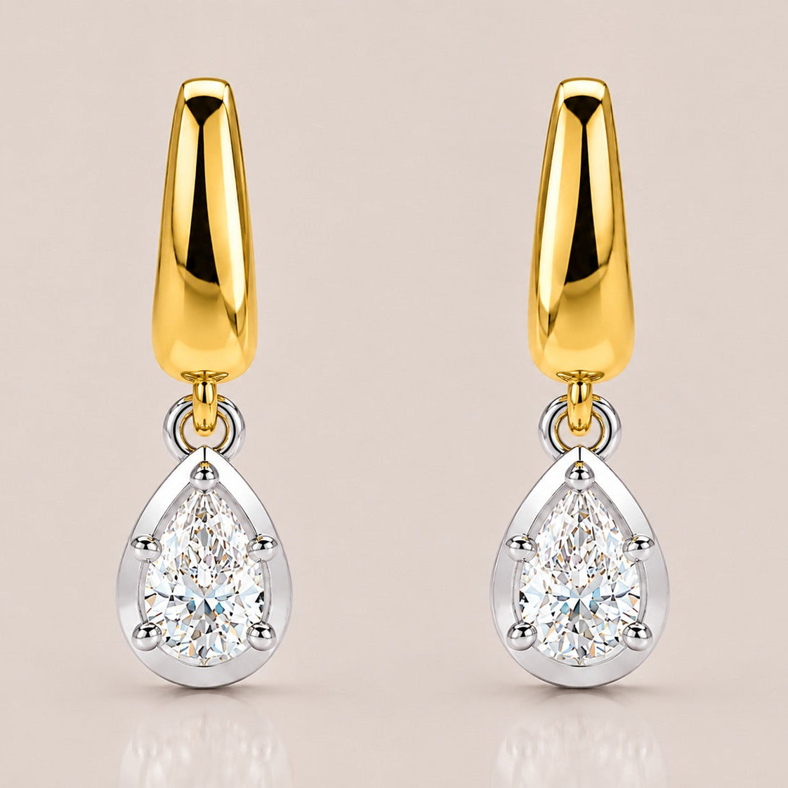 A pair of gold and silver drop earrings, each featuring a polished gold teardrop-shaped top and a pear-cut clear gemstone in a silver bezel setting below, shown on a light beige background.