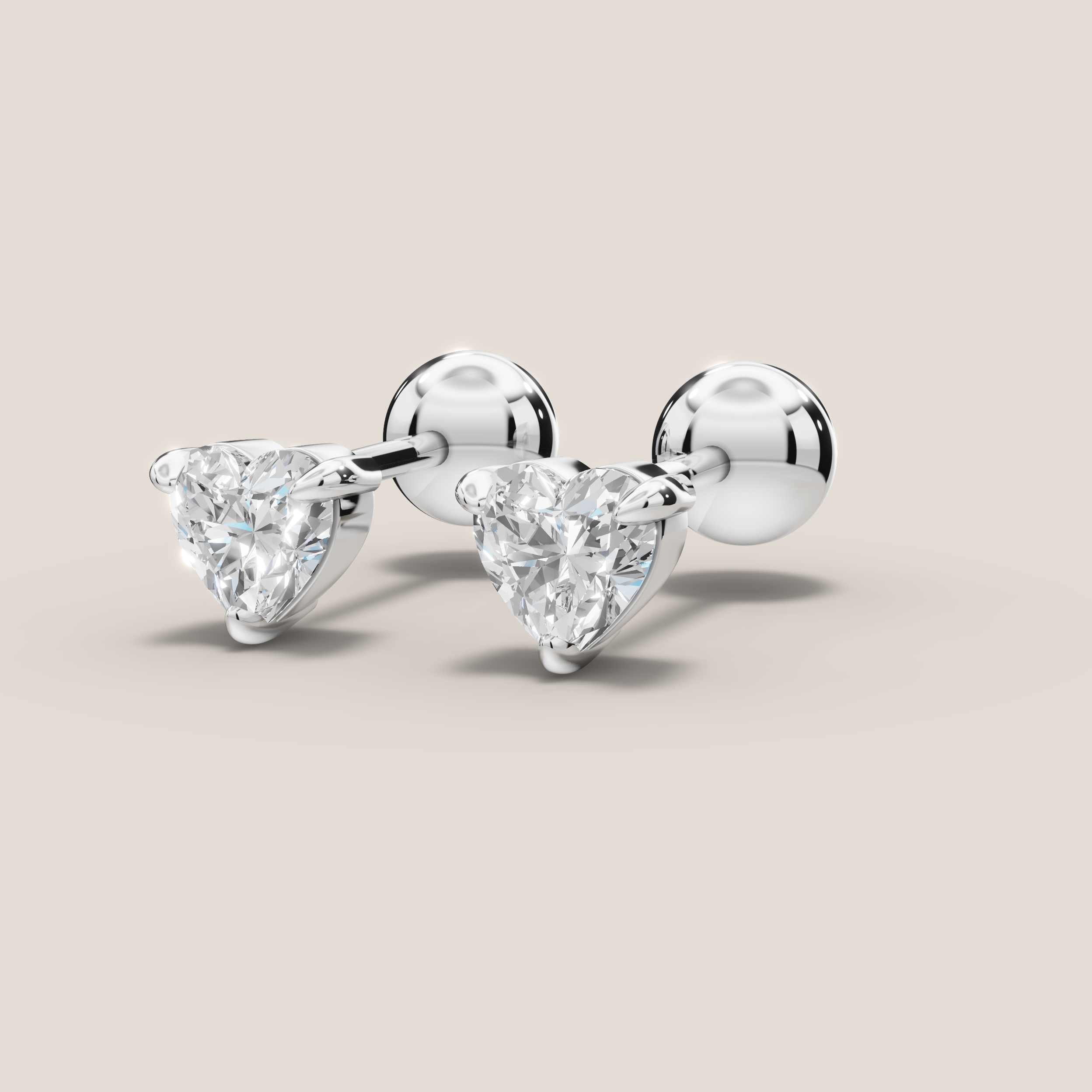 Pair of diamond stud earrings on a beige background