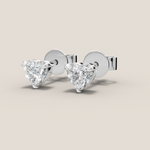 Pair of diamond stud earrings on a beige background