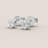 Pair of diamond stud earrings on a beige background