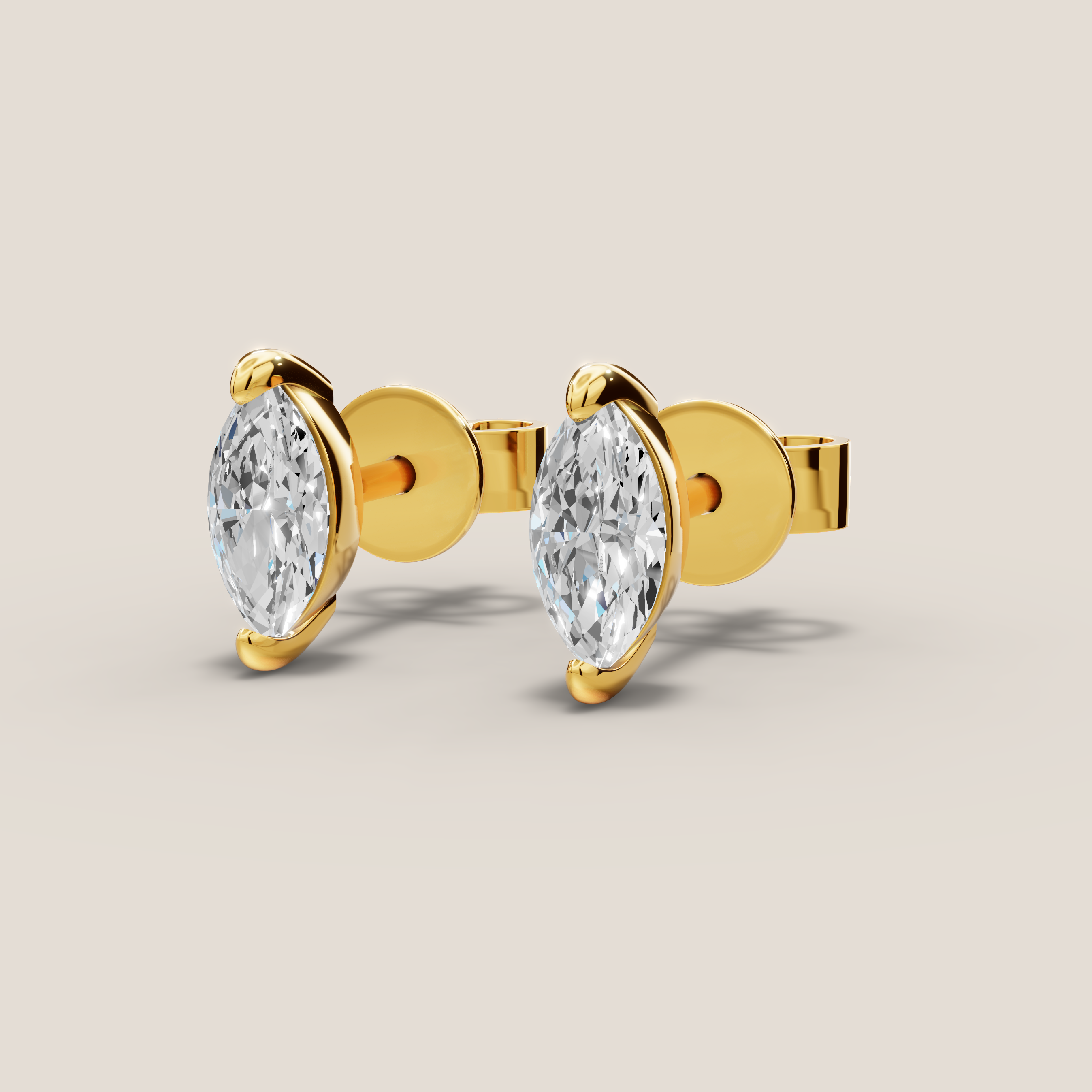 Gold earrings with pear-shaped clear gemstones on a beige background