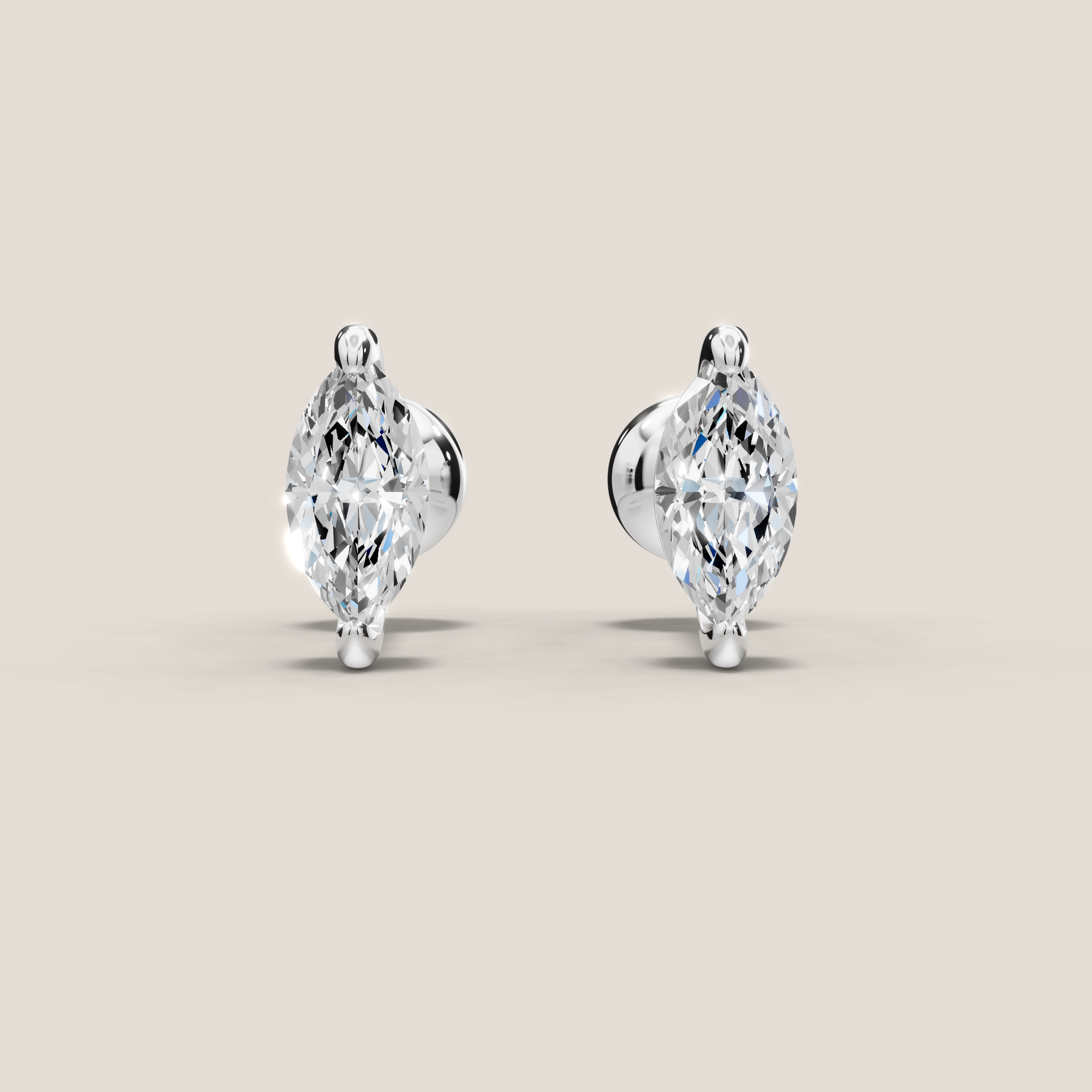 Pair of marquise-shaped diamond earrings on a beige background