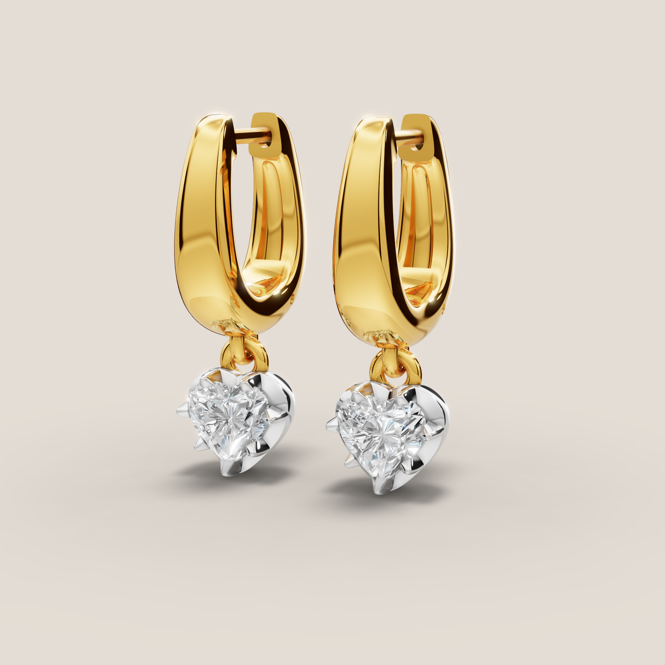 Gold hoop earrings with heart-shaped diamond drops on a light beige background