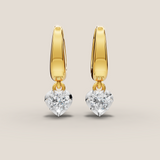 Gold hoop earrings with round gemstones on a beige background