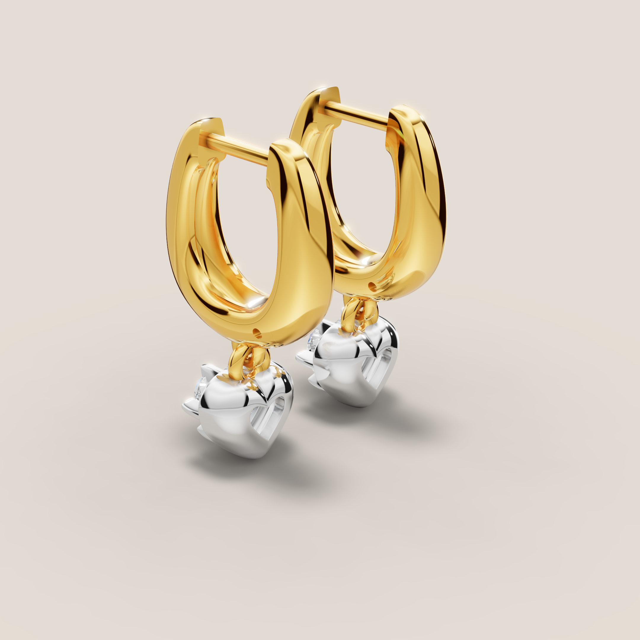Gold hoop earrings with silver heart charms on a beige background
