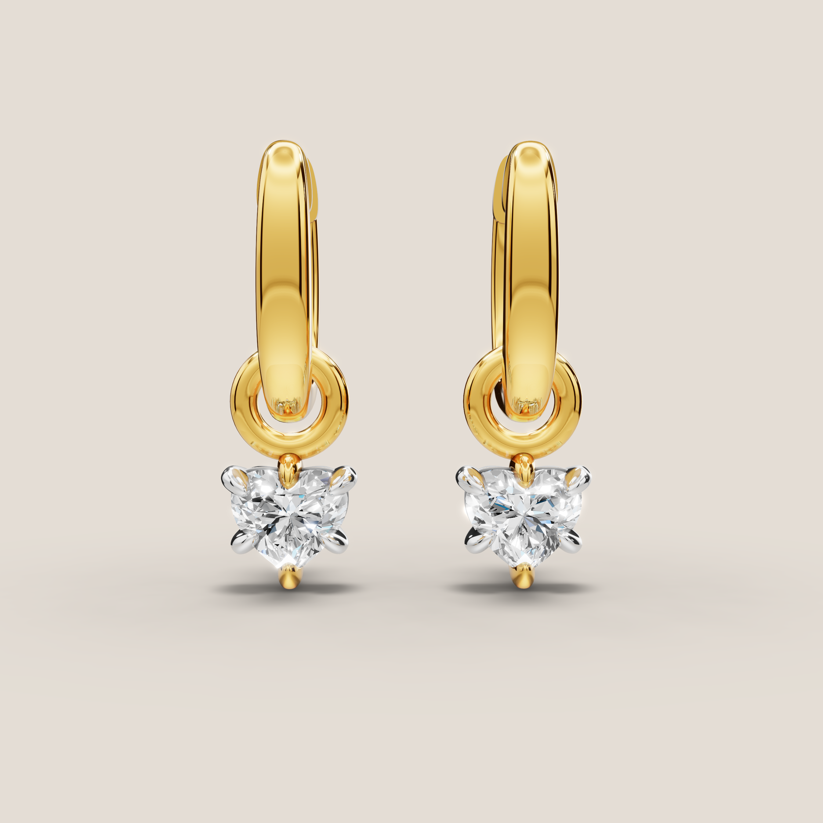 Gold hoop earrings with heart-shaped diamond drops on a beige background
