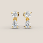 Gold and diamond earrings on a beige background