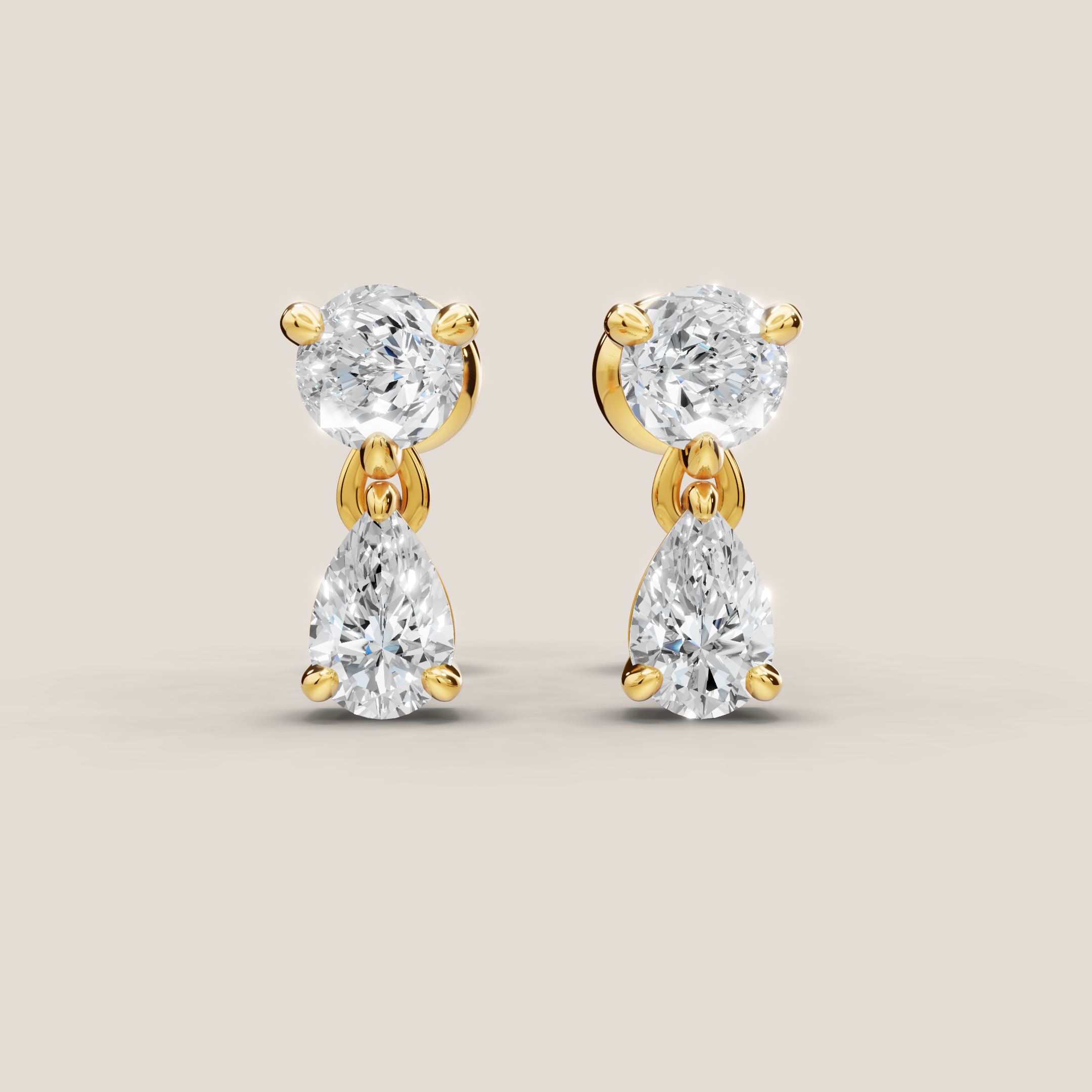 Gold and diamond earrings on a beige background