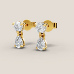 Gold earrings with clear gemstones on a beige background