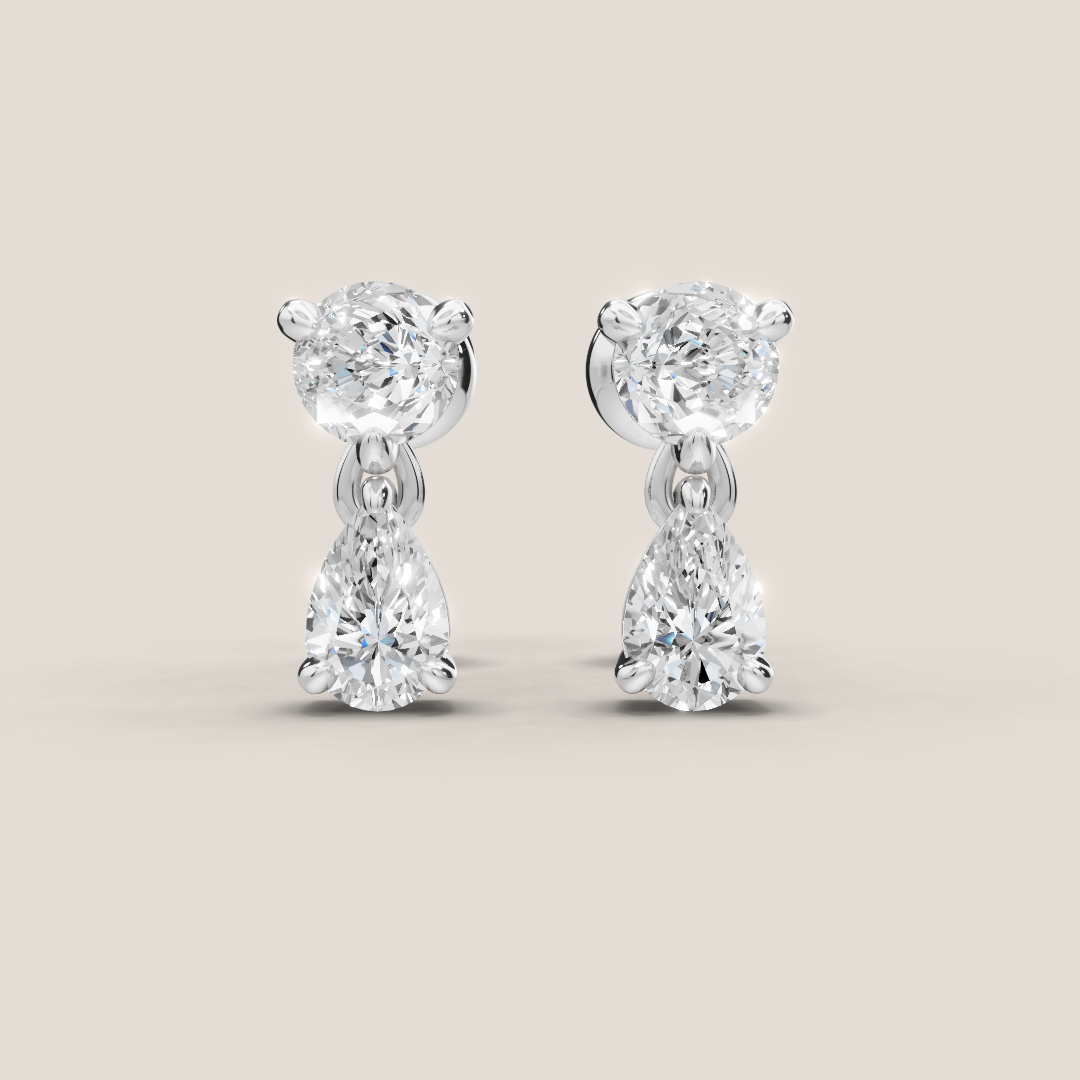 Pair of diamond earrings on a light beige background