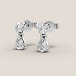 Pair of diamond earrings on a beige background