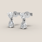 Pair of diamond earrings on a beige background