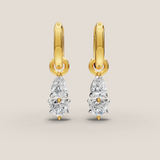Gold earrings with teardrop-shaped diamonds on a beige background