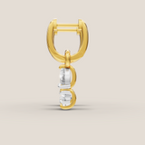 Gold and silver earring on a beige background
