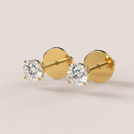 A pair of stud earrings featuring IGI-certified lab-grown diamonds set in a 14k gold setting, displayed against a white background.