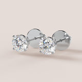 A pair of stud earrings featuring IGI-certified lab-grown diamonds set in a 14k gold setting, displayed against a white background.