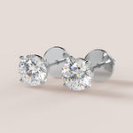 A pair of stud earrings featuring IGI-certified lab-grown diamonds set in a 14k gold setting, displayed against a white background.