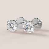 A pair of stud earrings featuring IGI-certified lab-grown diamonds set in a 14k gold setting, displayed against a white background.
