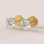 A pair of stud earrings featuring IGI-certified lab-grown diamonds set in a 14k gold setting, displayed against a white background.