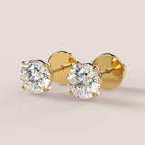 A pair of stud earrings featuring IGI-certified lab-grown diamonds set in a 14k gold setting, displayed against a white background.