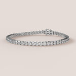 A tennis bracelet featuring lab-grown diamonds set in a double bezel in either white or yellow gold.