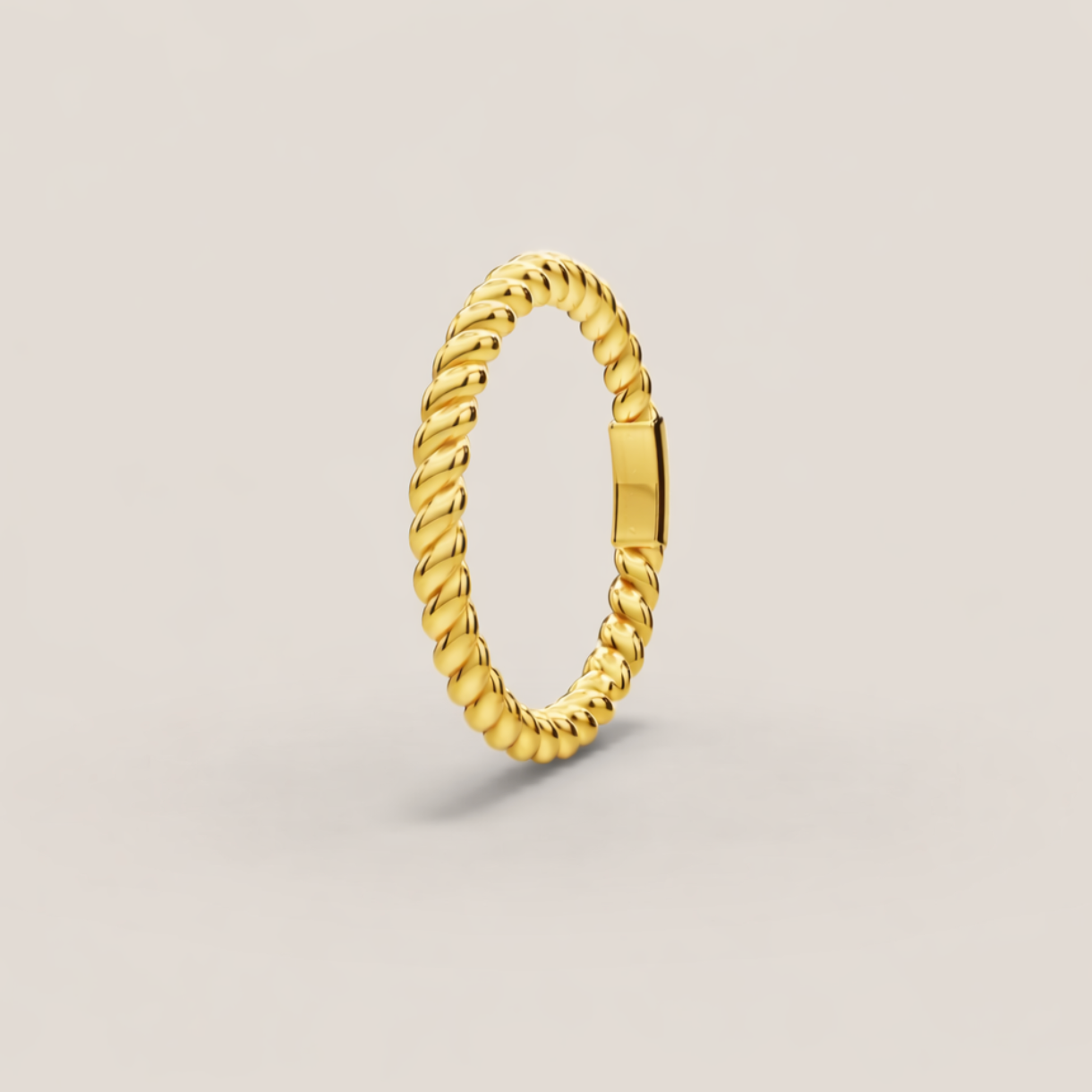 Gold ring with a textured design on a light gray background