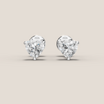 Heart-shaped diamond earrings on a beige background
