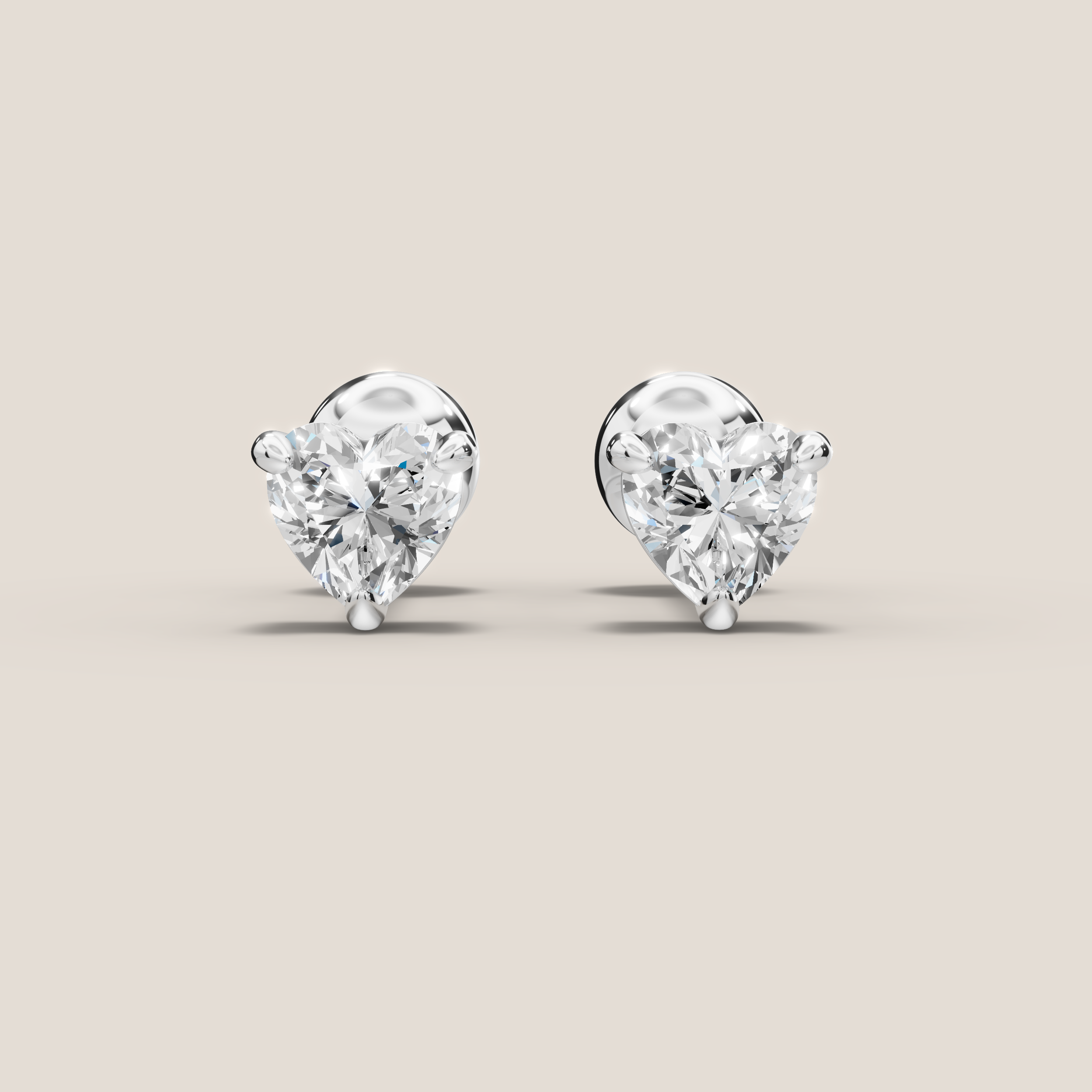 Heart-shaped diamond earrings on a beige background