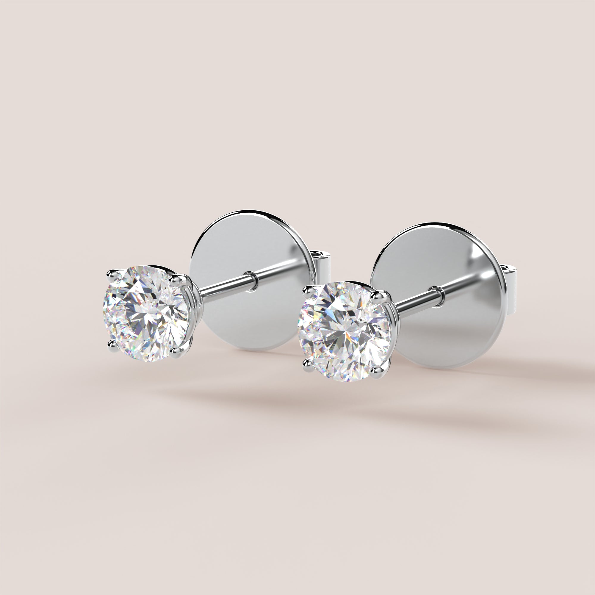 Pair of diamond stud earrings on a light beige background