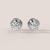 Pair of diamond stud earrings on a light beige background