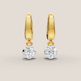 Gold hoop earrings with round gemstones on a beige background