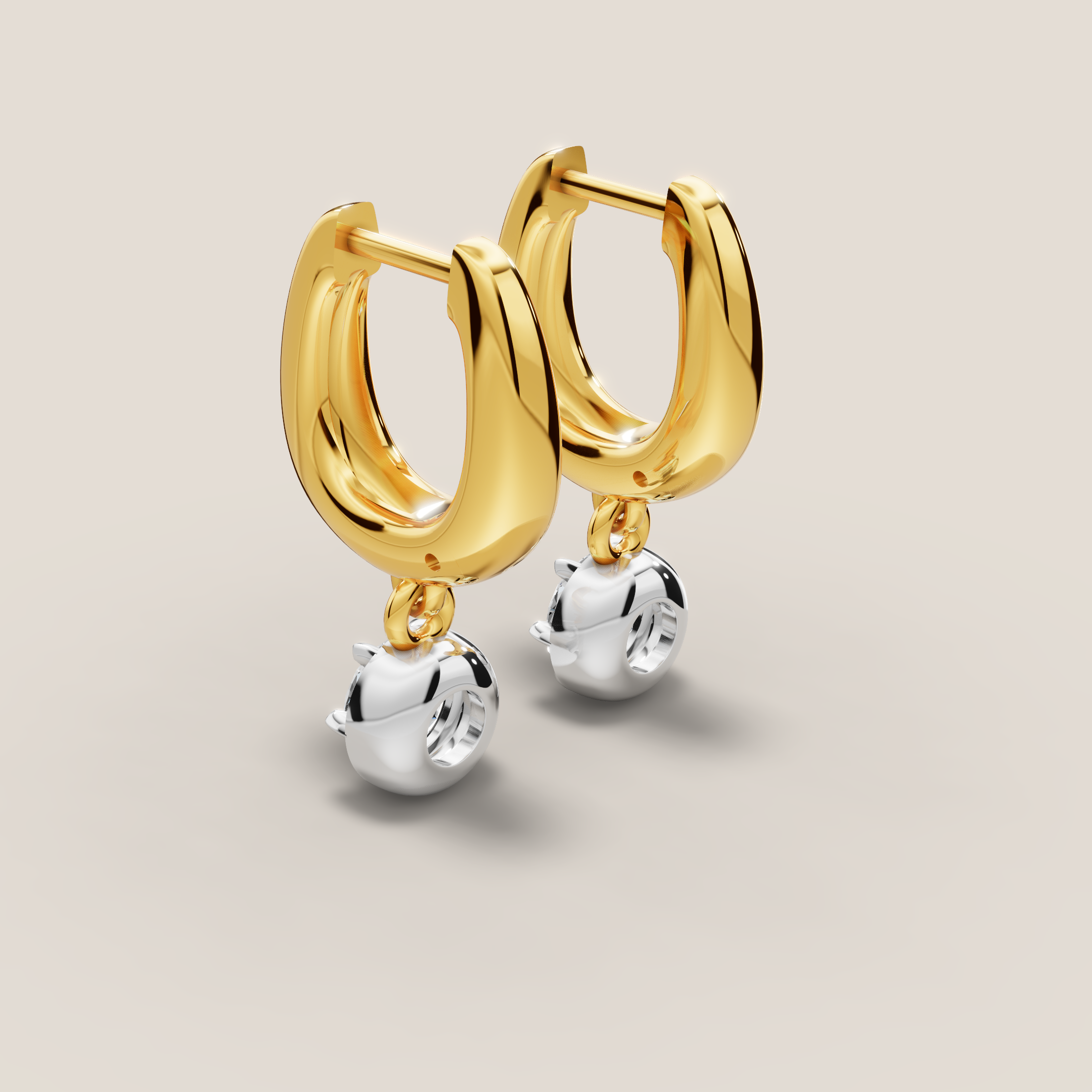 Gold hoop earrings with silver ball pendants on a beige background