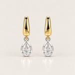 A pair of gold and silver drop earrings with pear-cut clear gemstones, displayed on a clean, light beige background.